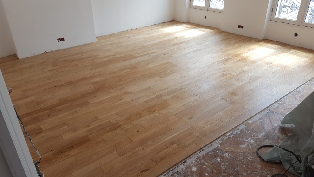 Pose (collage en plein) d'un parquet en chêne dans une salle à manger